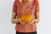 Kaboompics - Woman Holding Orange Pumpkin in Pink Sweater