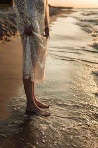 Kaboompics - Barefoot Woman in Sequin Dress at Waterline in Golden Hour Light