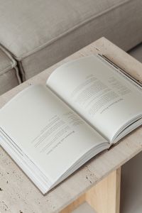 Kaboompics - Open Book Flat Lay on Travertine with Neutral Sofa Background