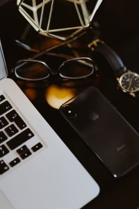 Kaboompics - Dark Workspace Detail with Smartphone, Glasses, Watch and Gold Decor