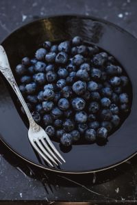 Kaboompics - Fresh blueberries on a black plate with vintage cutlery