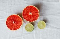 Kaboompics - Grapefruit Halves and Lime Slices on White Linen for Recipe Styling