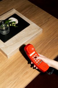 Kaboompics - Hand Holding Retro Red Telephone Above Coffee Table