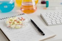 Kaboompics - Pills, Chemistry Flask and Keyboard on Laboratory Desk