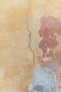 Kaboompics - Cracked Yellow Wall with Red Paint Layer