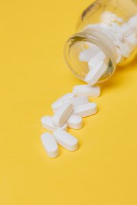 Kaboompics - Close-Up of White Tablets Spilling from Yellow Medicine Bottle