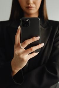 Kaboompics - Close-Up of a Smartphone in a Woman's Hand and Black Blazer