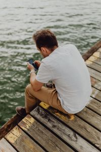 Kaboompics - Man Using Smartphone by the Water, Rear View