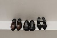 Kaboompics - Row of Brown and Black Leather Shoes on White Ledge