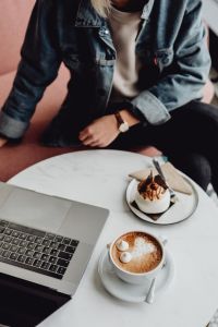 Kaboompics - Working with a laptop, meringue with whipped cream and coffee on white marble