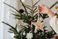 Kaboompics - Wooden Star Christmas Ornament Held near Tree Branch