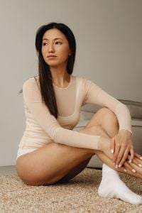 Kaboompics - Woman Sitting on a Cream Sofa in a Beige Long-Sleeve Top at Home