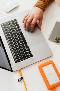 Kaboompics - Man works on a computer at his desk, mobile phone, portable hard drive