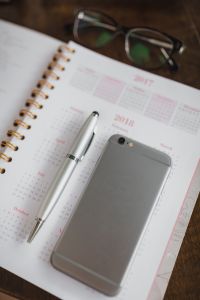 Kaboompics - Pink 2017-2018 Calendar with Eyeglasses, Smartphone and Silver Pen, Wooden Desk