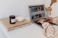 Kaboompics - Laptop Workstation with Woman’s Hands, Books and Candle