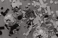 Kaboompics - Silver Disco Balls, Champagne Bottle and Confetti in a Party Flat Lay