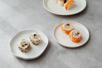 Kaboompics - Mixed Sushi Rolls on White Ceramic Plates with Gray Copy Space