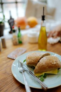 Kaboompics - Cafe Table With Sandwich and Golden Bottle
