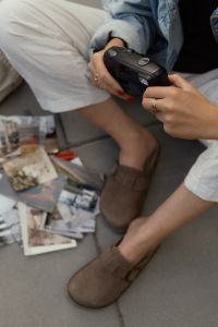 Kaboompics - Holding A Point And Shoot Film Camera With Printed Photos