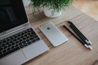 Kaboompics - Silver Acer laptop on a wooden desk with a green plant, pencils and an Apple iPhone