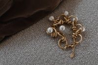 Kaboompics - Gold Link Bracelet with Pearl Beads on Gray Woven Fabric, Jewelry Still Life