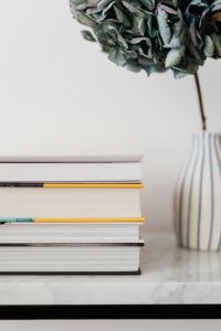 Kaboompics - Stacked Books Beside Hydrangea in a Striped Vase on Marble