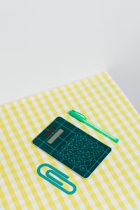 Kaboompics - Green Calculator, Pen and Paper Clip Flat Lay