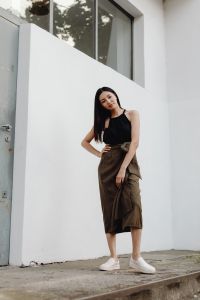 Kaboompics - Casual Street Style Woman in Brown Midi Skirt against White Architectural Background