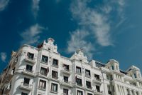 Kaboompics - Ornate White Madrid Apartment Facade with Sculpted Roofline Beneath Blue Sky