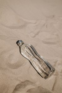 Kaboompics - Clear Glass Water Bottle on the Sand