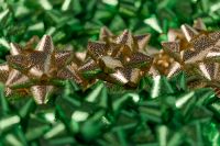 Kaboompics - Gold Gift Bows on Green Metallic Texture