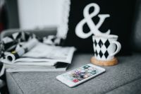 Kaboompics - Selective Focus Coffee Cup, Magazine and Smartphone on Textured Sofa