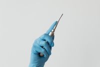 Kaboompics - Dental Root Elevator Held by Blue Gloved Hand