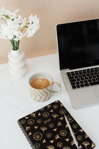Kaboompics - Home Office Coffee, Pen and White Flowers beside Laptop