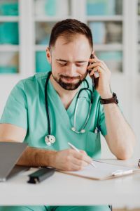 Kaboompics - Doctor Taking Phone Call While Writing Notes