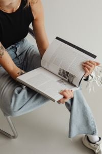 Cozy Home Reading Lifestyle with Books, Light Jeans and a Small Dog on a Neutral Sofa