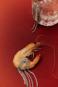 Kaboompics - Shrimp and Silver Chains beside a Crystal Glass