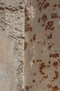 Kaboompics - Crumbling Limestone Edge beside Rust-Stained Plaster, Weathered Stone Wall Texture