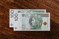 Kaboompics - Two 100 Polish Zloty Notes on Rustic Wood, Minimal Cash Still Life