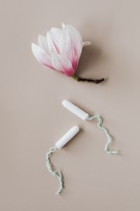 Kaboompics - Tampons Styled Beside a Pink Magnolia Flower, Vertical Still Life
