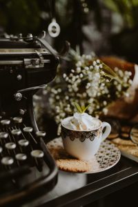 Vintage Coffee Break Lifestyle with Whipped Cream Coffee, Cookies, Ornate Cup and Typewriter