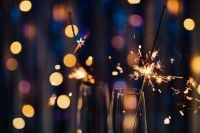 Kaboompics - Close-Up of Sparklers Resting in Champagne Flutes with Blurred Lights