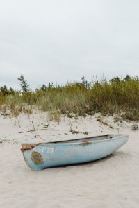 Kaboompics - Weathered Blue Fishing Boat on Baltic Beach with Dune Grass and Copy Space