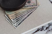 Close-Up of Layered Cash and Linen on a Marble Table