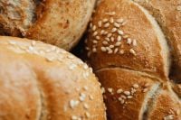 Kaboompics - Macro Close-Up of Sesame-Topped Kaiser Rolls with Golden Crust and Rustic Bread Texture