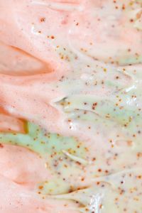 Kaboompics - Vertical Macro of Pale Peach and Mint Skincare Cream with Exfoliating Granules
