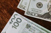 Kaboompics - Polish 100 Zloty and US Five-Dollar Banknotes on a Wooden Table