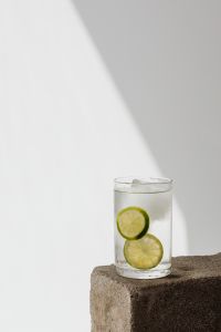 Kaboompics - Low-Set Glass of Lime Water with Ice on Stone, Minimal Sunlit Summer Drink Photo