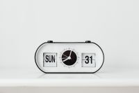 Kaboompics - Close-Up of White Flip Desk Clock with Black Calendar and Date Display on a White Surface