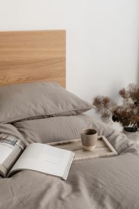 Kaboompics - Coffee Cup and Open Book on Gray Bedding